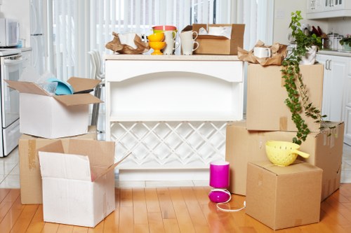 Packed moving boxes and furniture ready for transport in NW6